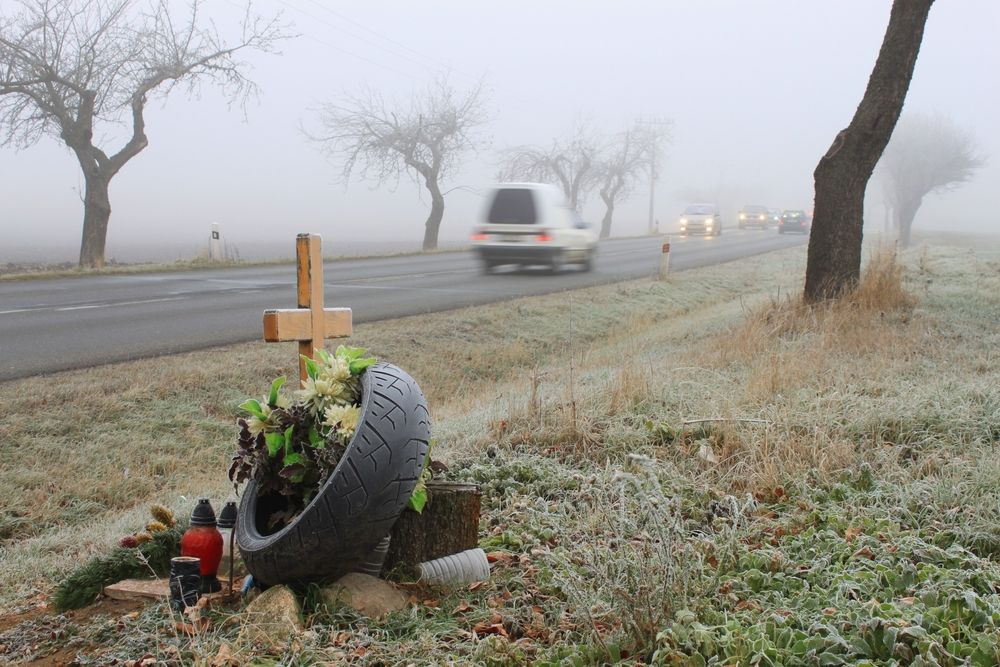Cross, tire and memorial on side of highway